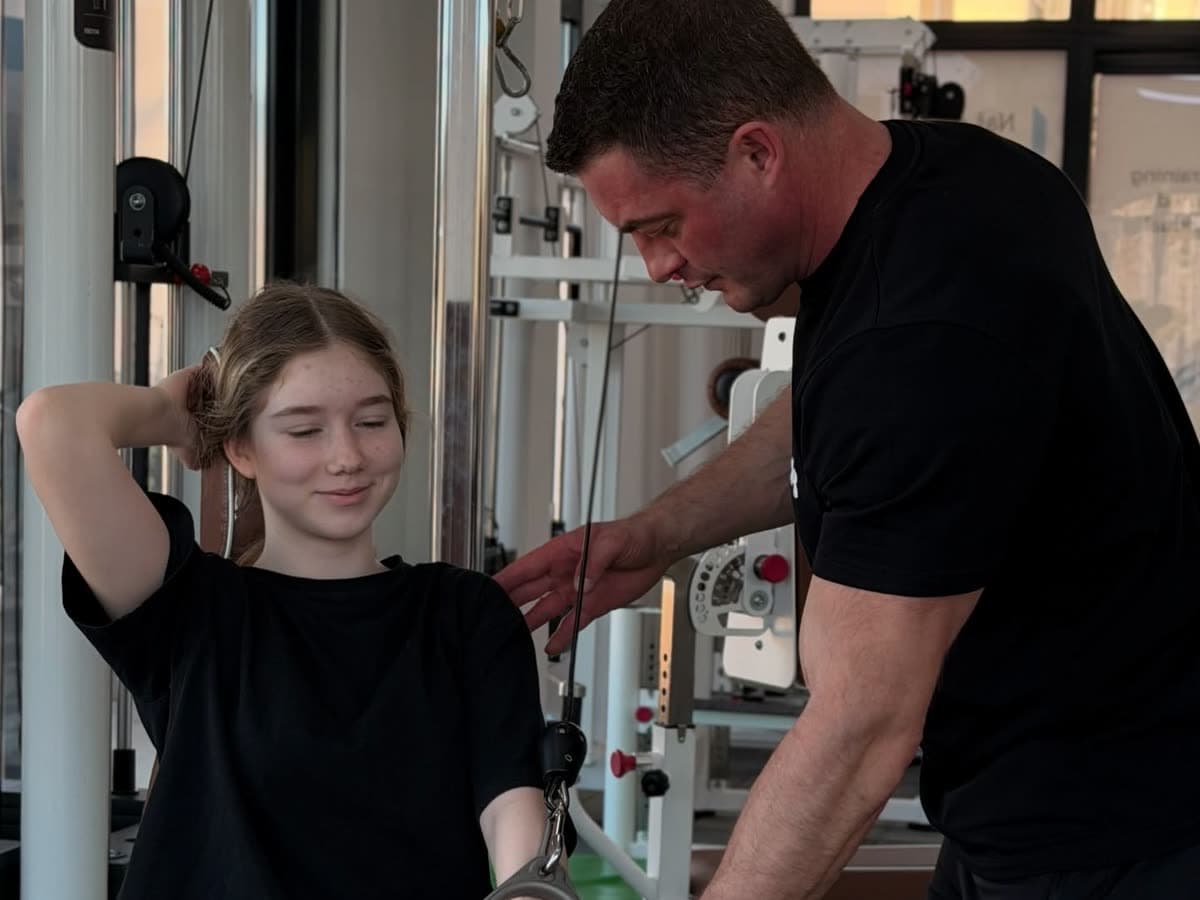 A therapist guiding a seated patient through resistance-band work