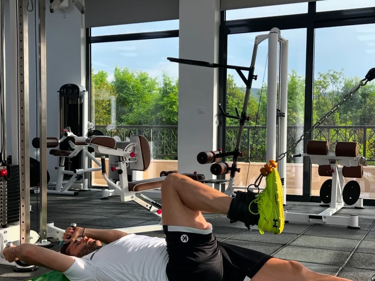 A patient working the legs on a mat in the clinic gym
