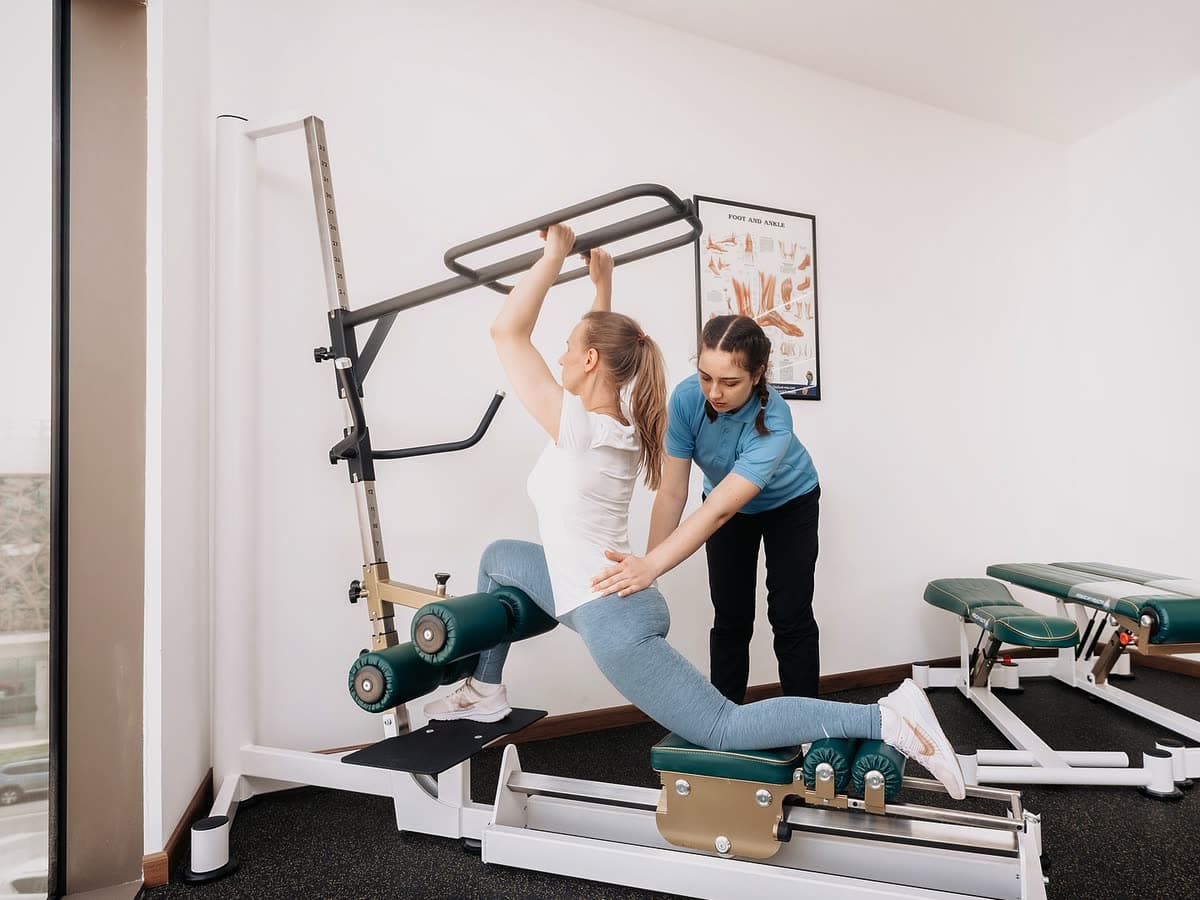 A therapist guiding a patient on a reformer