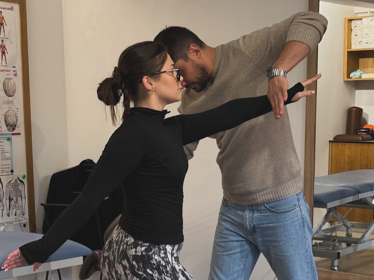 A therapist assessing a standing patient’s shoulder movement